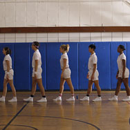 6 dancers lined up inside a gym