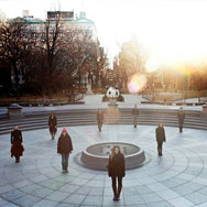 Nine people standing spread out in Washgington Square Park in winter attire